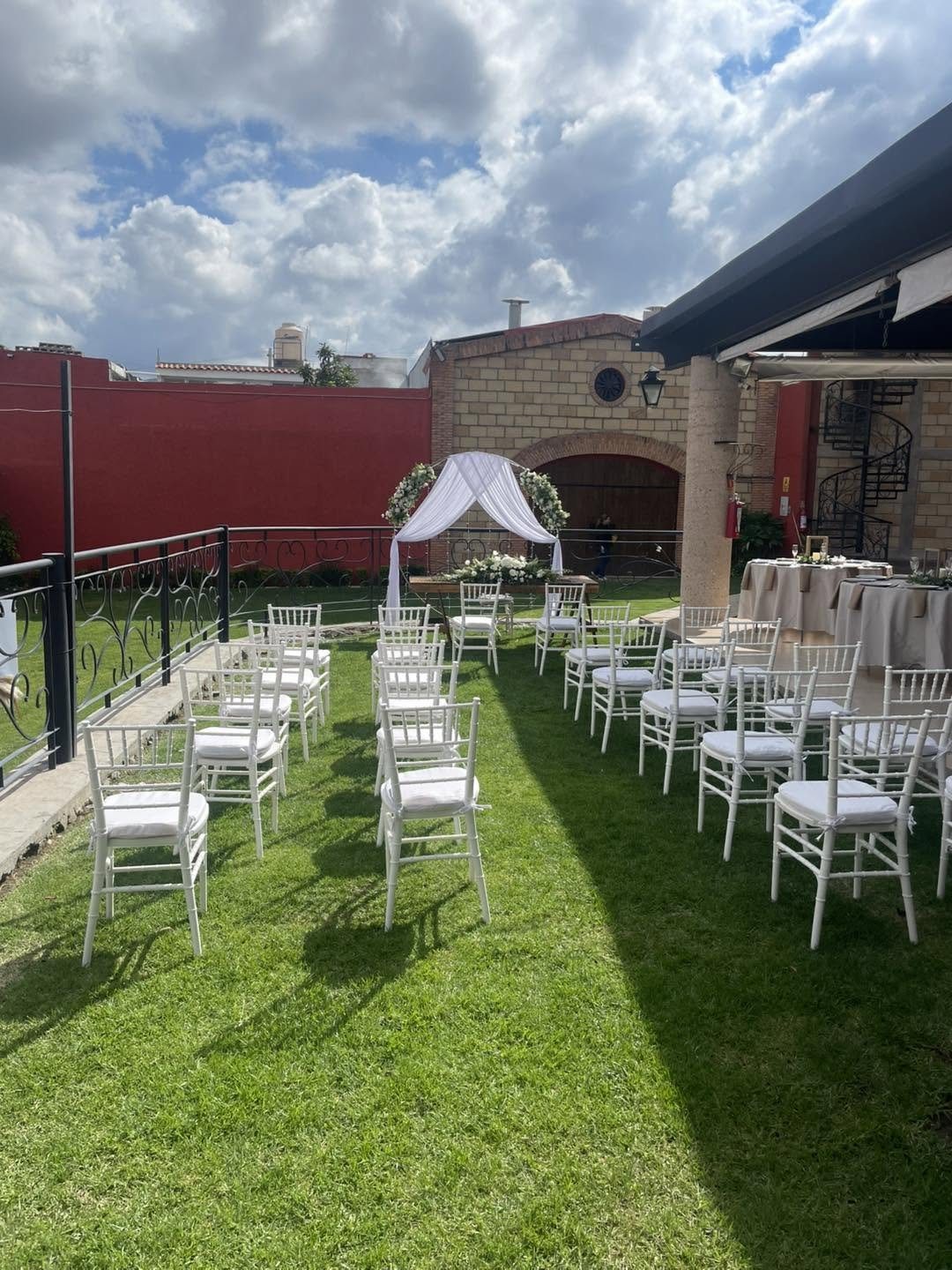 Ceremonia montada en el jardín de El Realejo, con sillas blancas y arco floral bajo cielo abierto